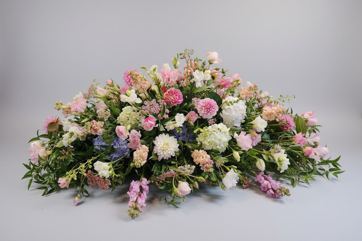 Floral arrangement with pink, white, and green flowers on a gray background