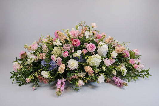 Floral arrangement with pink, white, and green flowers on a gray background